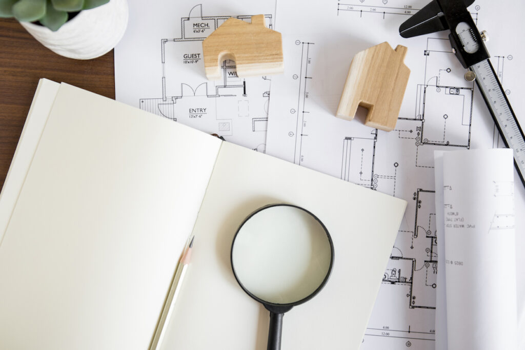 notebook-near-drafts-house-figures